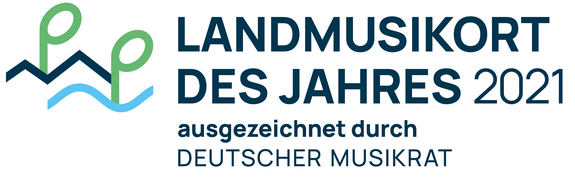 Weißes Schild mit blauer Schrift Landmusikort des Jahres 2021 ausgezeichnet durch Deutscher Musikrat. Links neben der Schrift ist das Logo vom Deutscher Musikrat