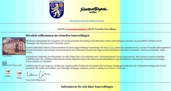 Screenshot der Startseite der Website www.saarwellingen.de im Jahr 1998. Farbverlauf im Hintergrund von blau, gelb, blau. In der Überschrift steht Saarwellingen online und was Gemeindewappen. Darunter das Grußwort des damaligen Bürgermeisters Werner Geibel mit einem Foto des Rathauses.